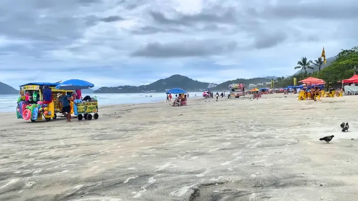 Praia de Ubatuba com c&eacute;u limpo e mar calmo