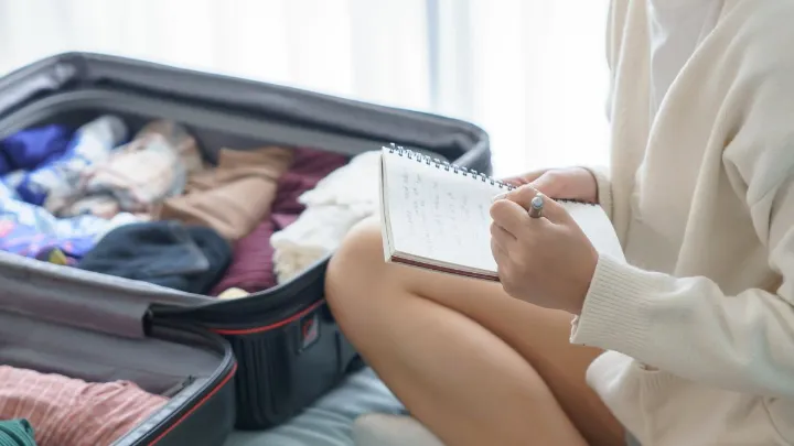 Mala aberta com roupas dobradas, acess&oacute;rios de viagem e itens pessoais organizados